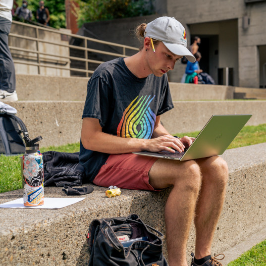 Lewis & Clark Law School student working on a laptop in the amphitheater.