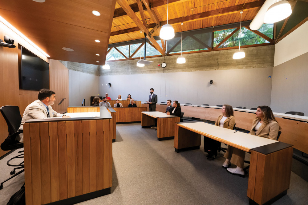 “Judge Matt Bergman '89 looks on as students practice litigation skills: Ashwin Kushwaha '25, Ron Sluck Jr. '26, Nad...