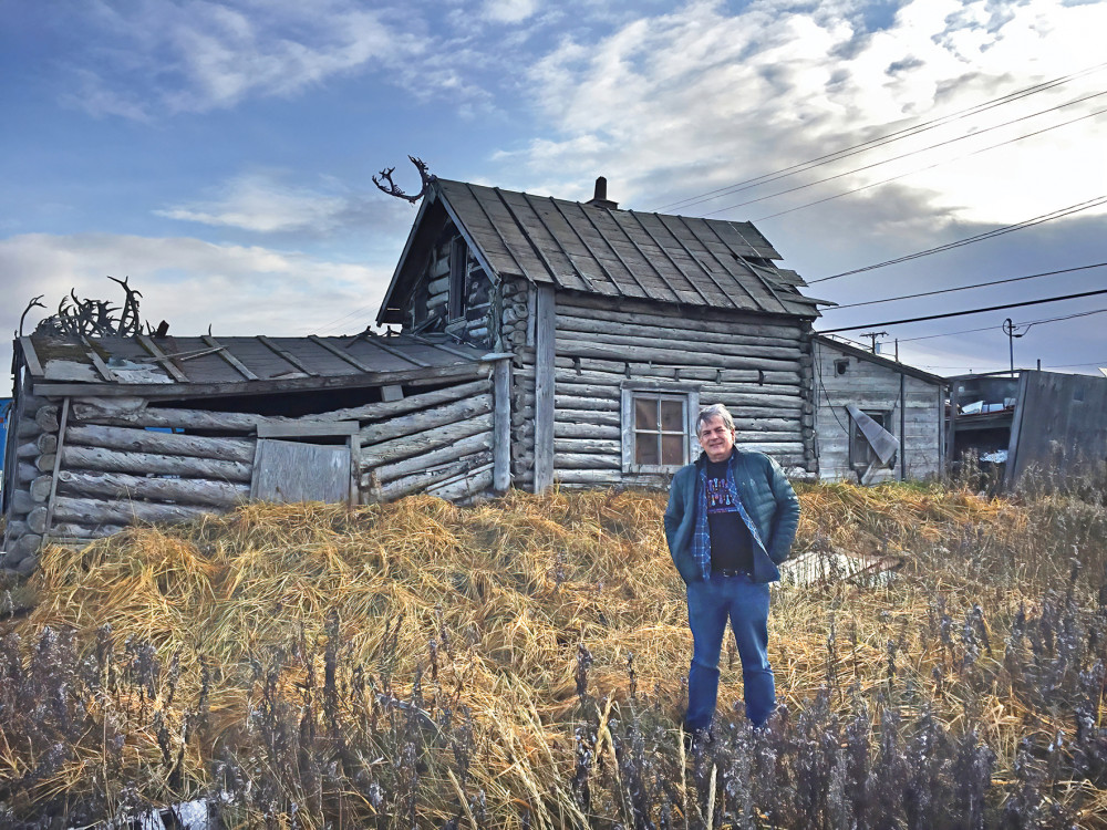 Alaska Legal Services Corporation staff attorney Michael Cagle '17 bucks the wind in front of one of Kotzubue's oldest, and now abandoned...