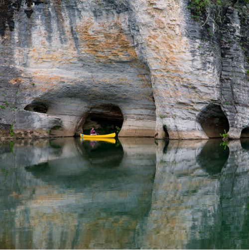 A canoer exploring the Buffalo National River and the unique karst geology of the area.