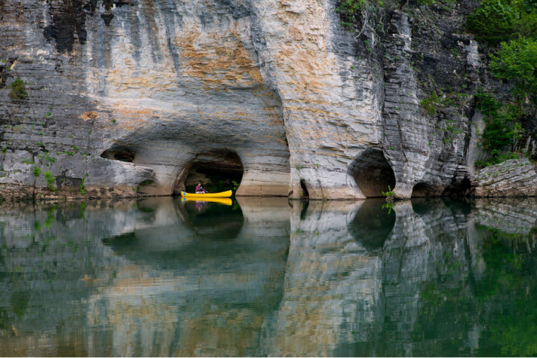 A canoer exploring the Buffalo National River and the unique karst geology of the area.