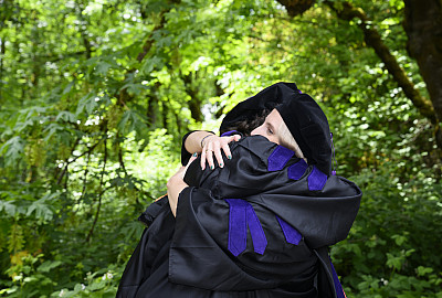Two graduates hugging.